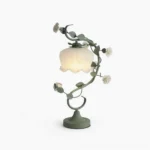 Sage green rose vine table lamp with ruffled frosted milk-white glass shade, front view on pure white background