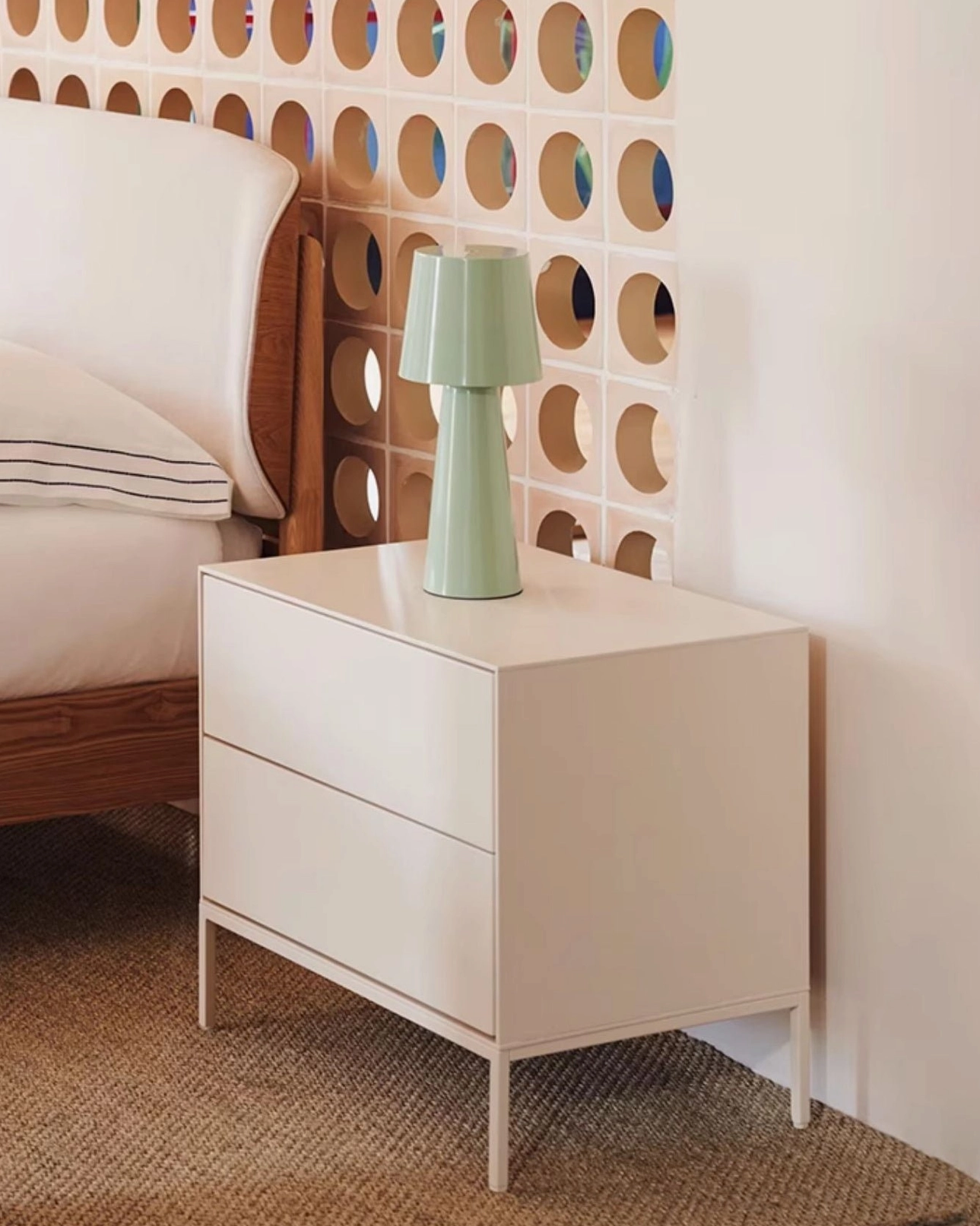 Sage green matte table lamp on white Scandinavian nightstand in minimalist bedroom
