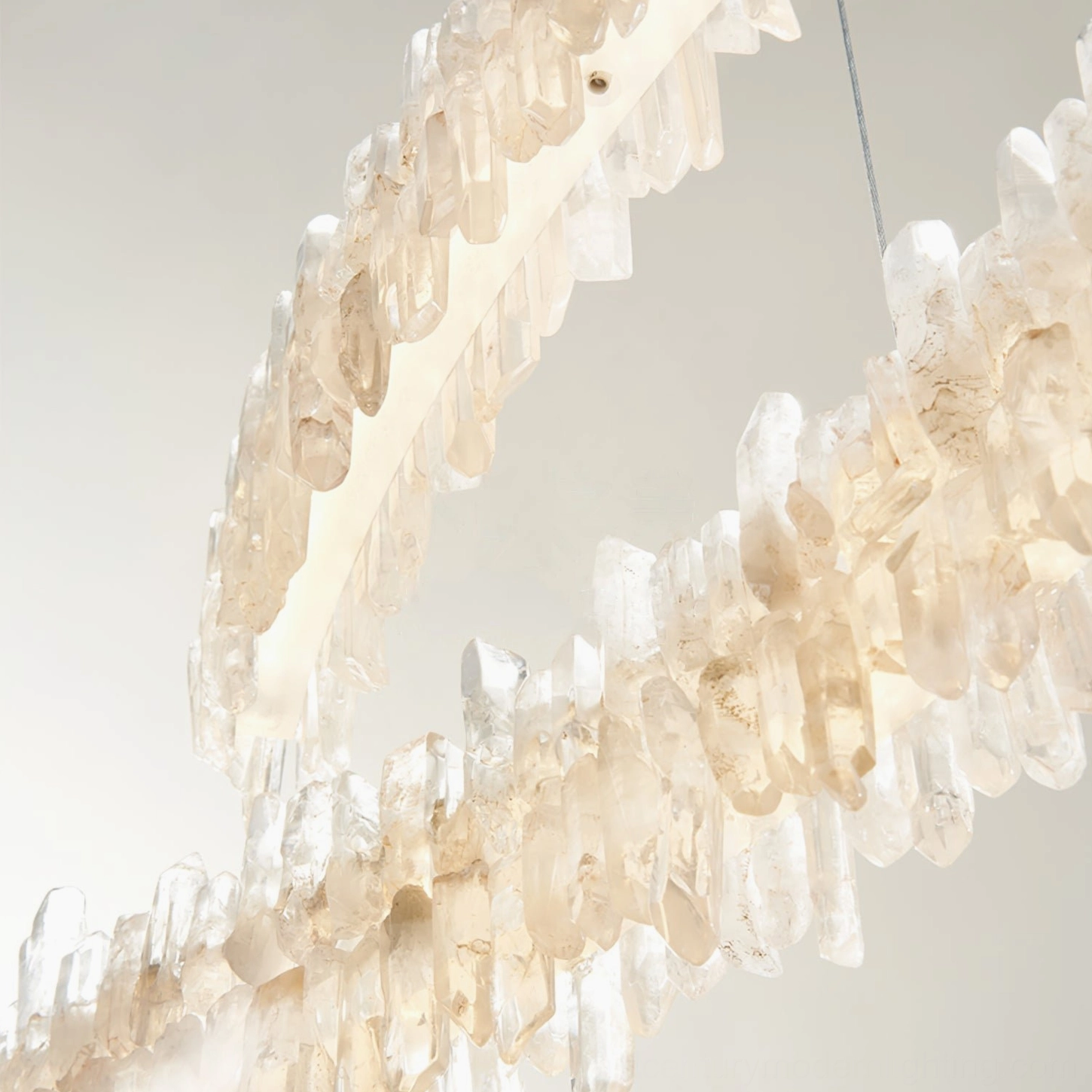 Close-up detail of Sarella chandelier curved crystal stone clusters with rose gold metal frame texture