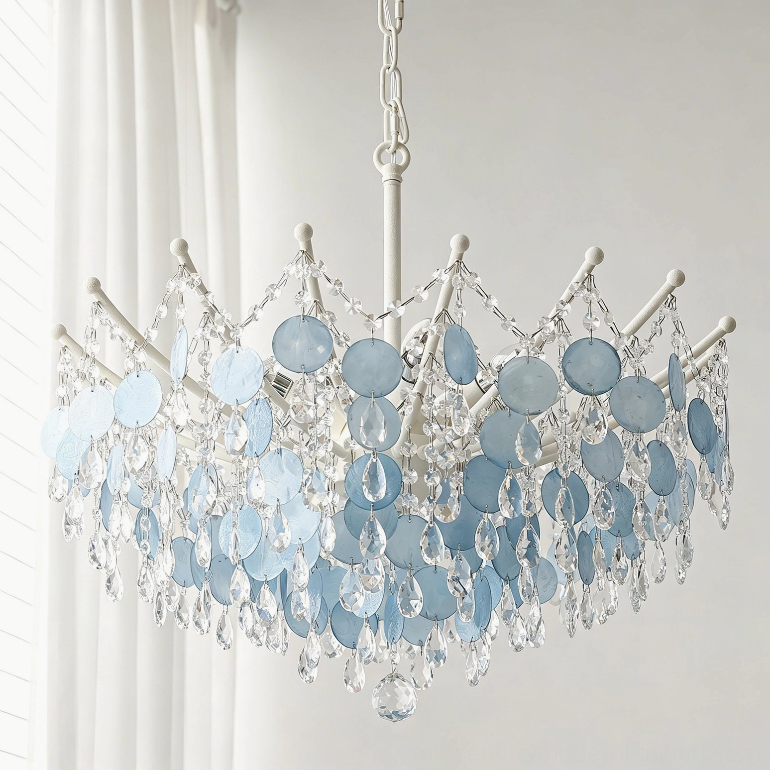 Close-up front view of tiered capiz shell and crystal beads with white metal frame, layered pendant details visible