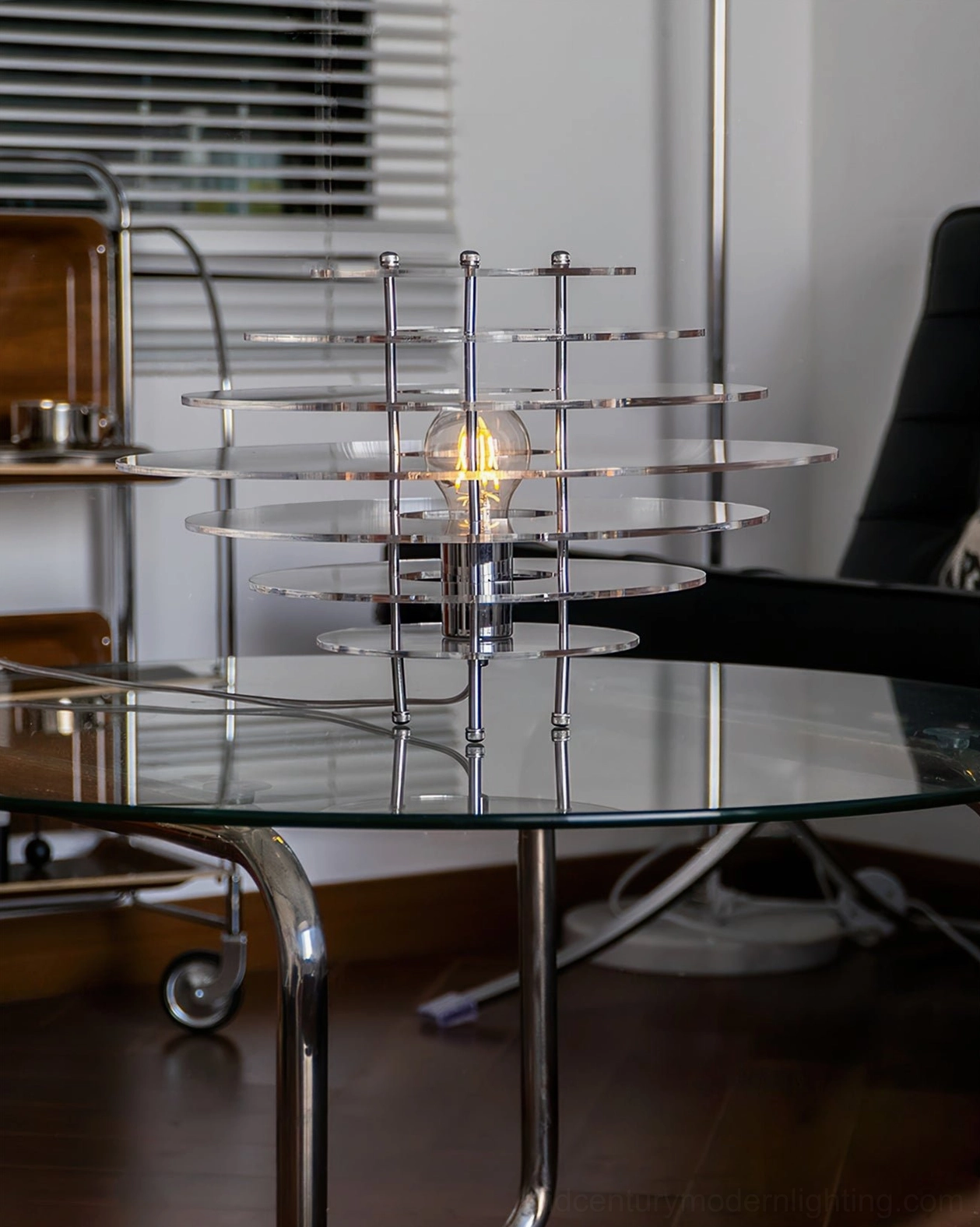 Saturn chrome acrylic lamp wide side angle in living room with glass coffee table - sleek industrial minimalist design