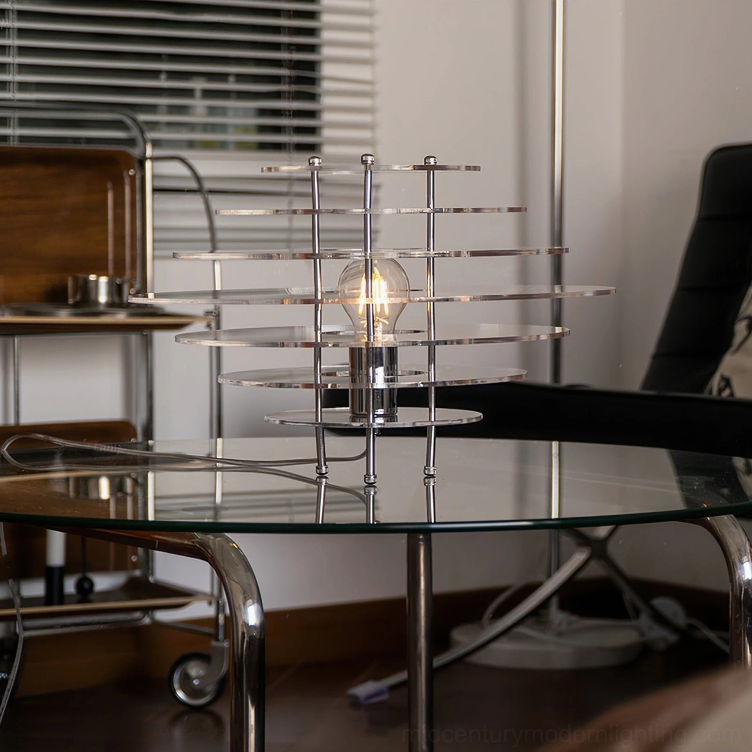 Saturn lamp side three-quarter view on living room console with leather accent chair - chrome finish modern minimalist
