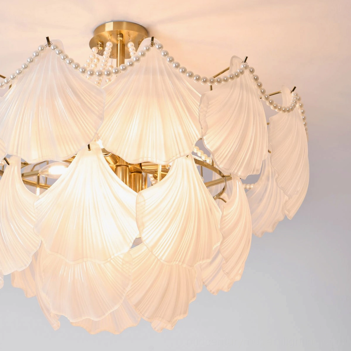 Architectural detail of scallop shell chandelier showing precision glass layering and brass frame construction
