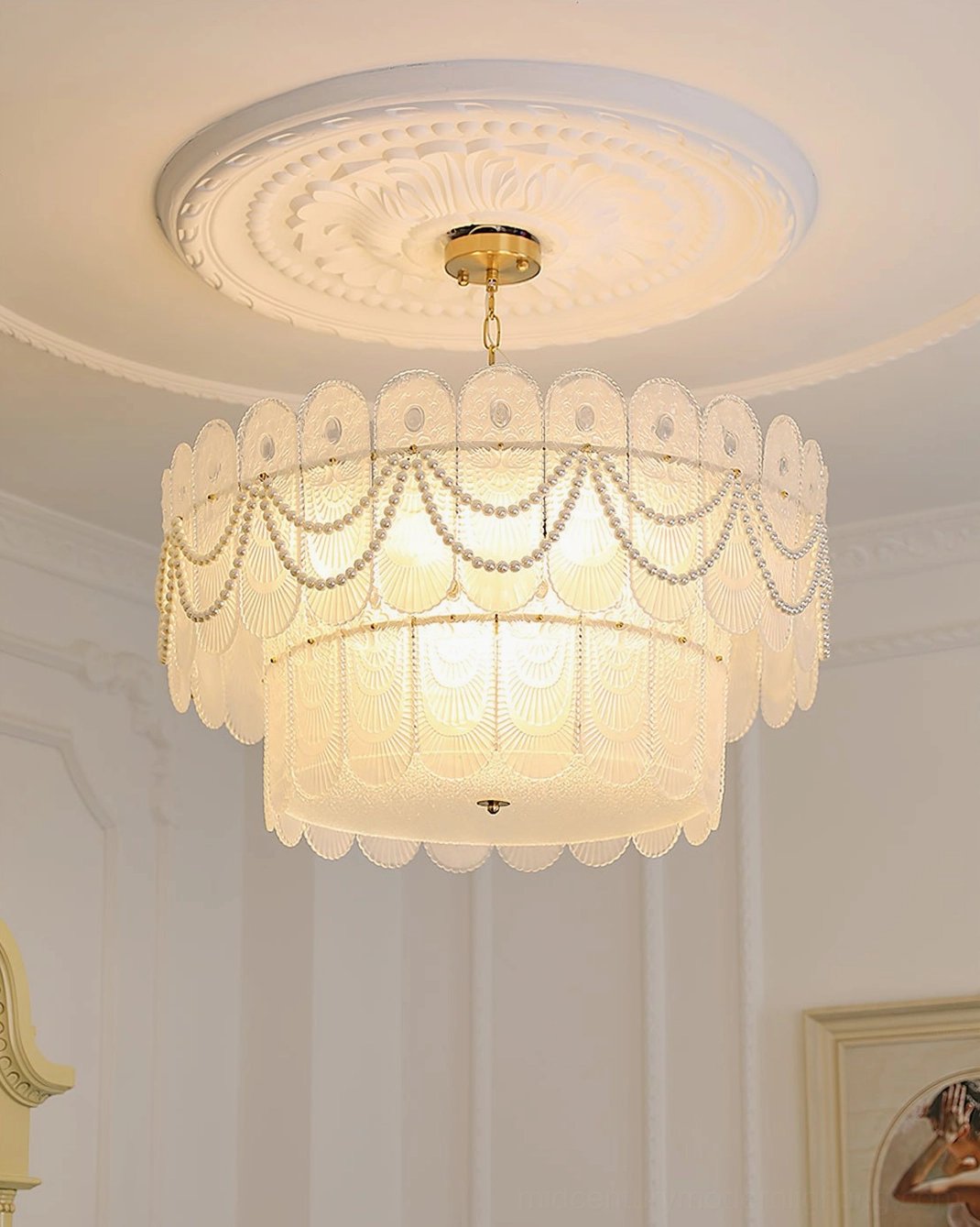 Two-tier glass chandelier installed in neutral French-style room with soft wall tones, upward perspective showing clean ceiling integration and warm lighting