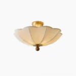Scalloped pleated semi-flush ceiling light with brushed brass hardware and off-white fabric shade, direct overhead view on white background