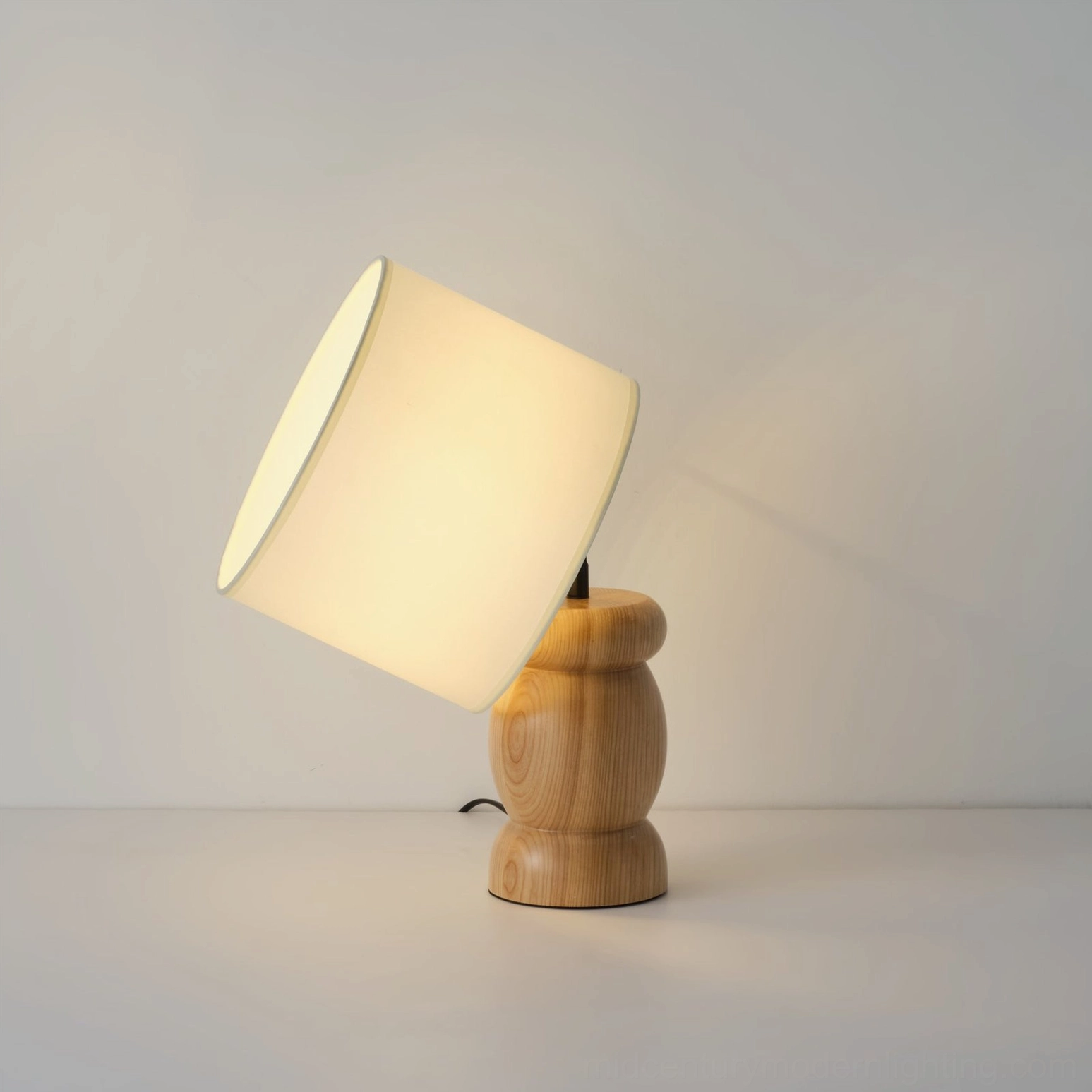 Elegant wood table lamp with angled linen-like shade, side view on studio white background, Scandinavian design