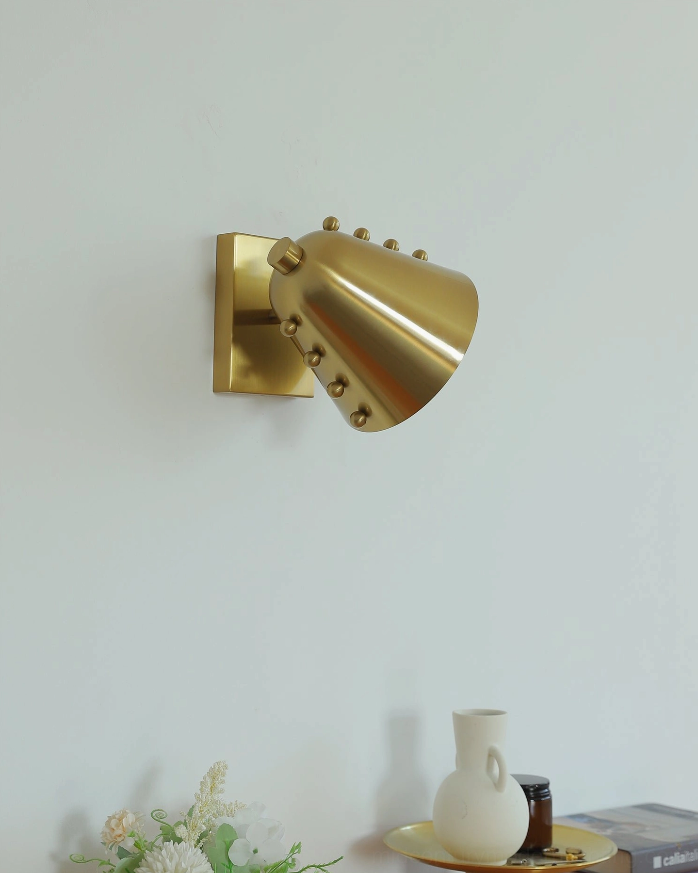 Geometric wall sconce detail shot showing spherical stud pattern on shade surface