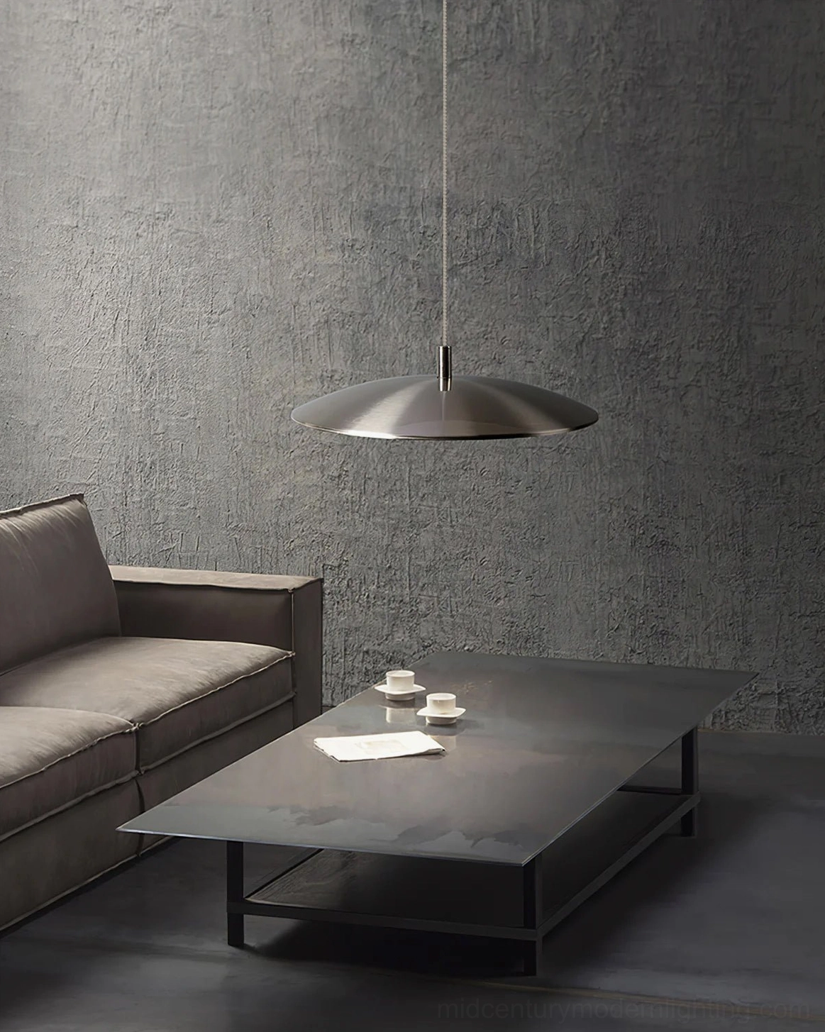 Silver scope pendant light side view in contemporary living room with concrete walls