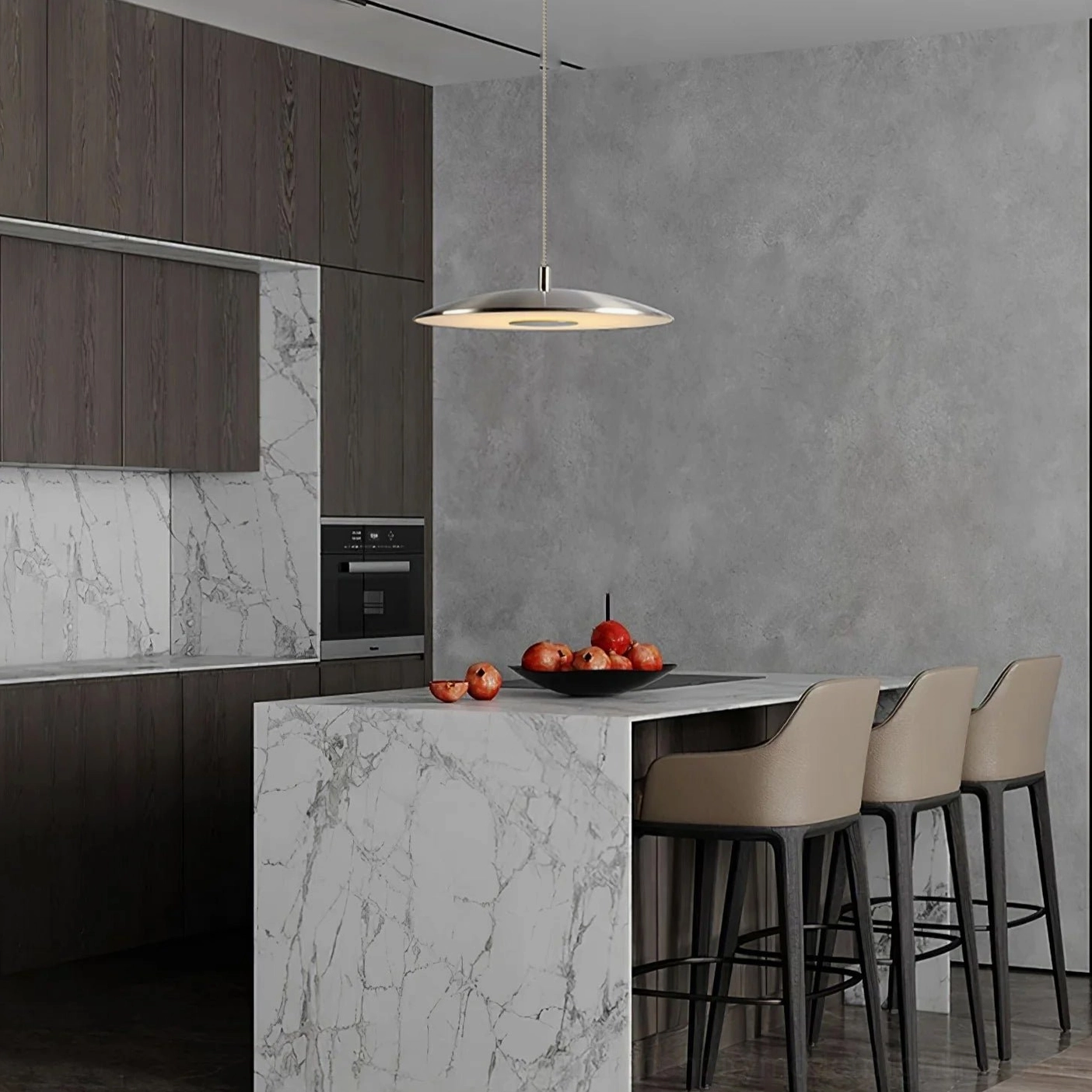 Silver disc pendant fixture above marble and dark wood kitchen island dining area