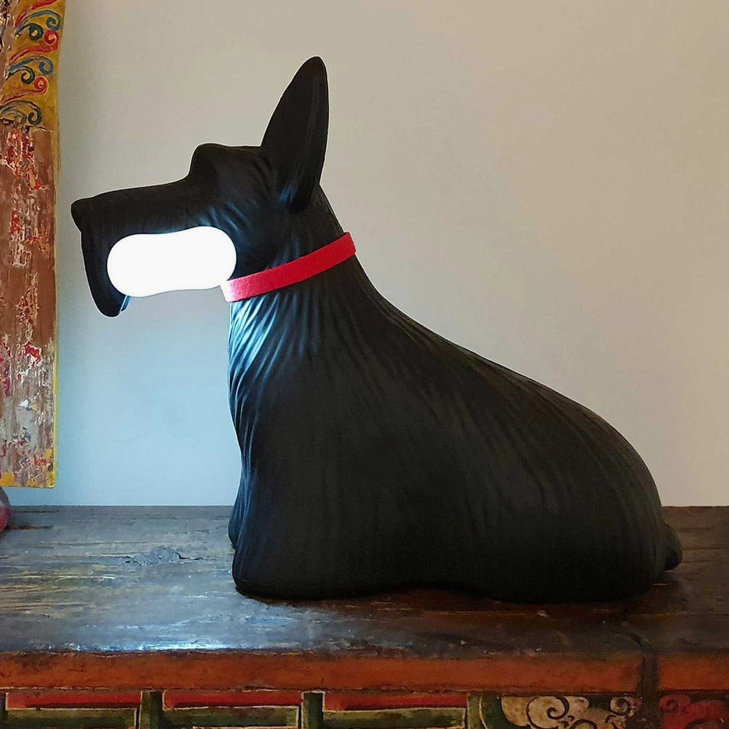 Black Scottie terrier lamp with textured resin finish and red collar on vintage wooden table, three-quarter rear view