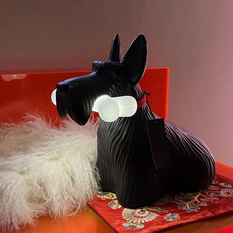 Scottie dog lamp with textured black finish and red collar, displayed indoors with decorative cushion and textured surfaces