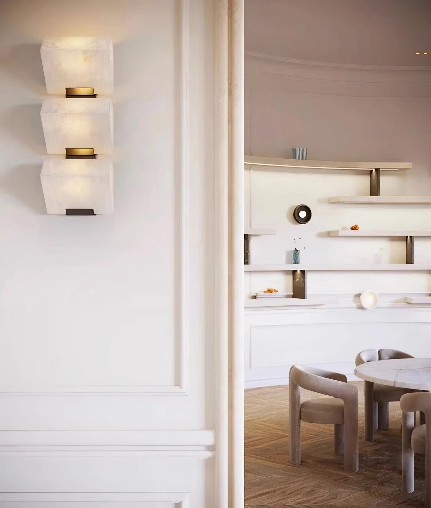 Tiered alabaster wall lamp with brass-toned mounting hardware in modern dining room entryway, showcasing warm light distribution