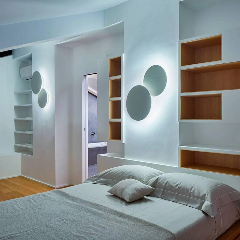 Sculptural geometric disc wall lamp with warm diffused illumination and soft shadow interplay in minimalist setting