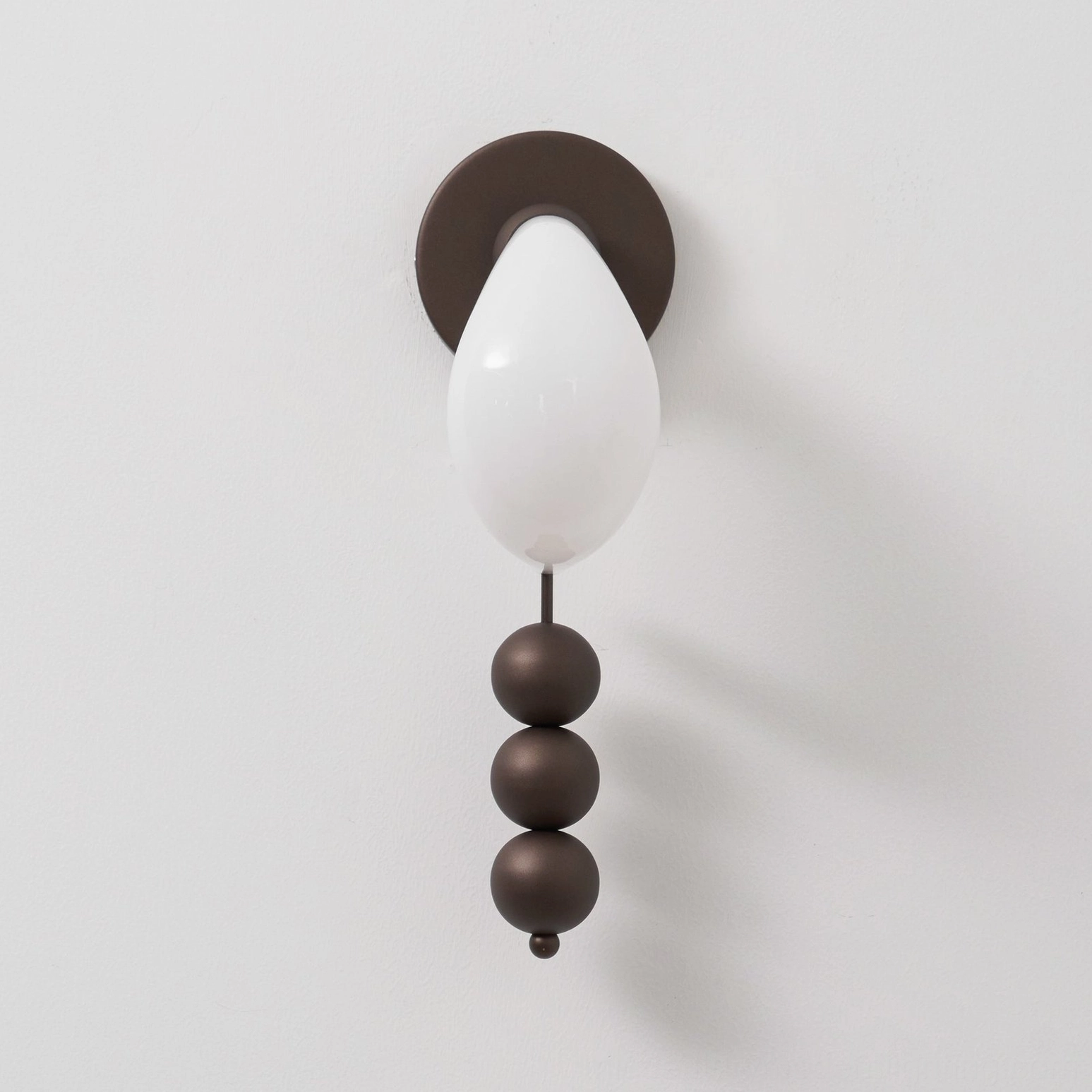 Sculptural glass wall sconce combining curved organic forms with geometric metal spheres, mid-century modern aesthetic