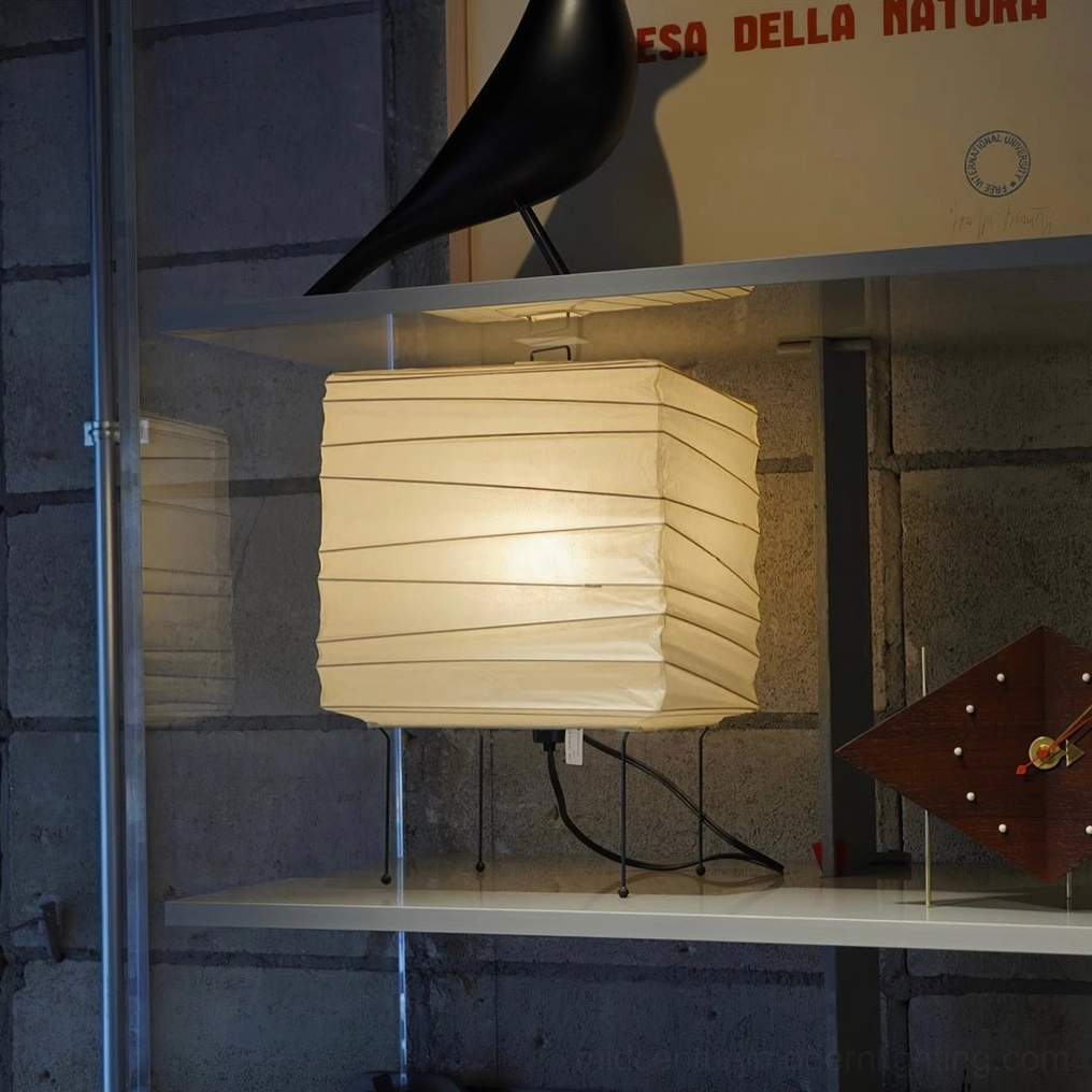 Handcrafted washi paper table lamp displayed in modern glass cabinet with contemporary bird sculpture and designer objects, gallery presentation