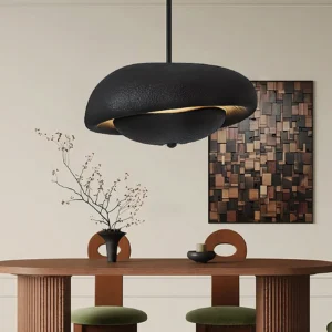 Organic resin pendant light fixture in matte black installed in residential dining area with warm ambient lighting