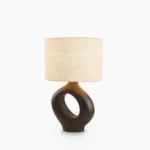 Sauce sculptural resin table lamp with hollow ceramic base, front view on white background, minimalist modern design
