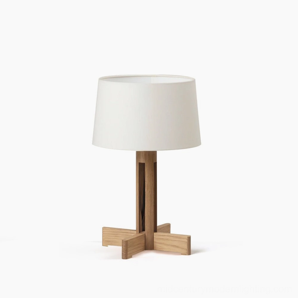 Sculptural wooden table lamp with cross base and white linen shade, front view studio shot