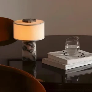 Beige marble table lamp on luxury bedside table with warm ambient lighting and nightstand decor