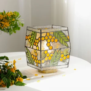 Seed Table Lamp three-quarter view on white round table with yellow flowers and polished brass base
