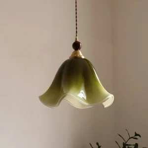 Green gradient Selene pendant light hanging in minimalist interior corner with twisted brown fabric cord and walnut wood accents