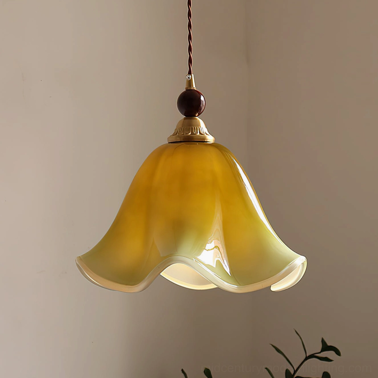 Selene botanical pendant light with walnut wood bead and brass accent details in soft lighting