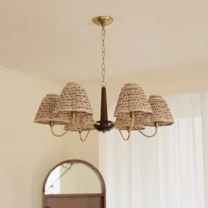 Mid-century modern Selva chandelier installed in French-style home interior with arched mirror and sheer curtains, warm vintage ambiance with glowing beige patterned fabric shades