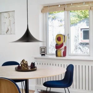 Black semi pendant light suspended above dining table in warm Nordic interior with vintage wooden furniture and retro decor
