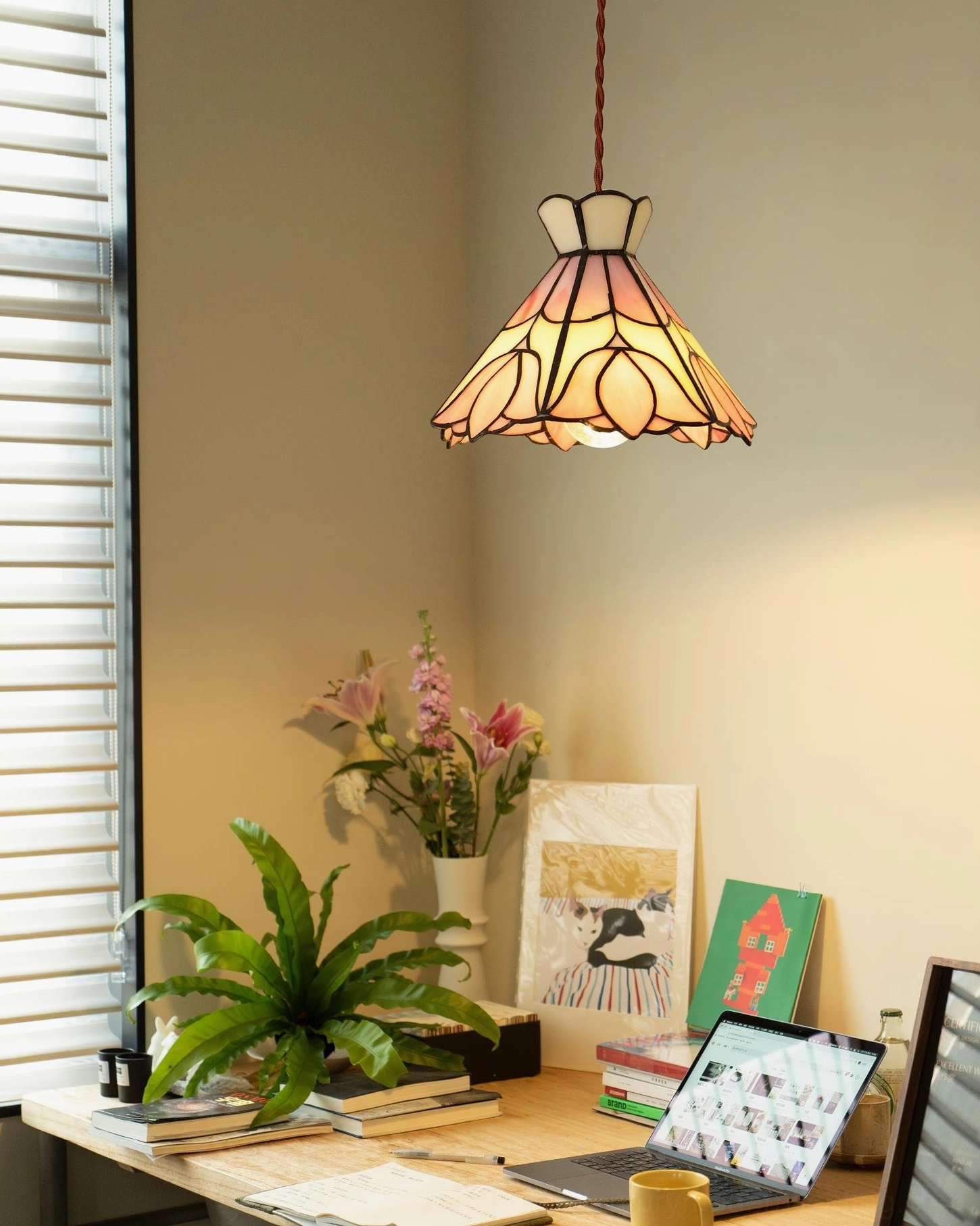 Serena pink stained glass pendant light with decorative brass accents in contemporary home interior setting