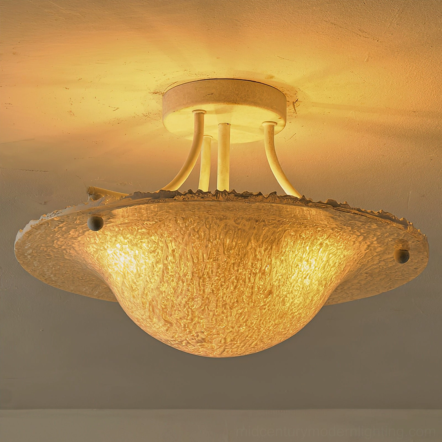 Serilda ceiling light with beige metal base and amber-toned textured illuminated glass shade, mounted view