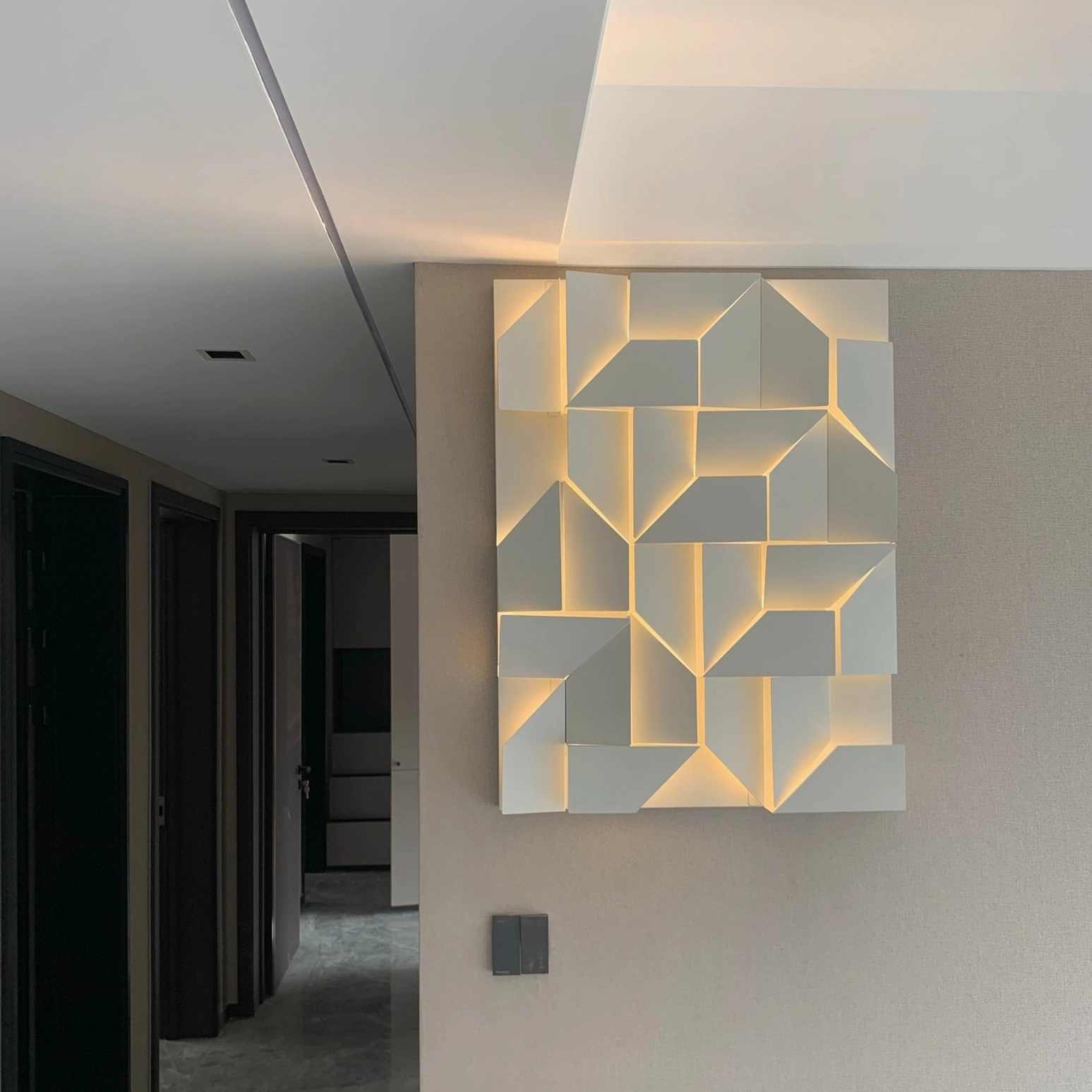 Geometric wall-mounted sconce with laser-cut aluminum frame, LED backlighting