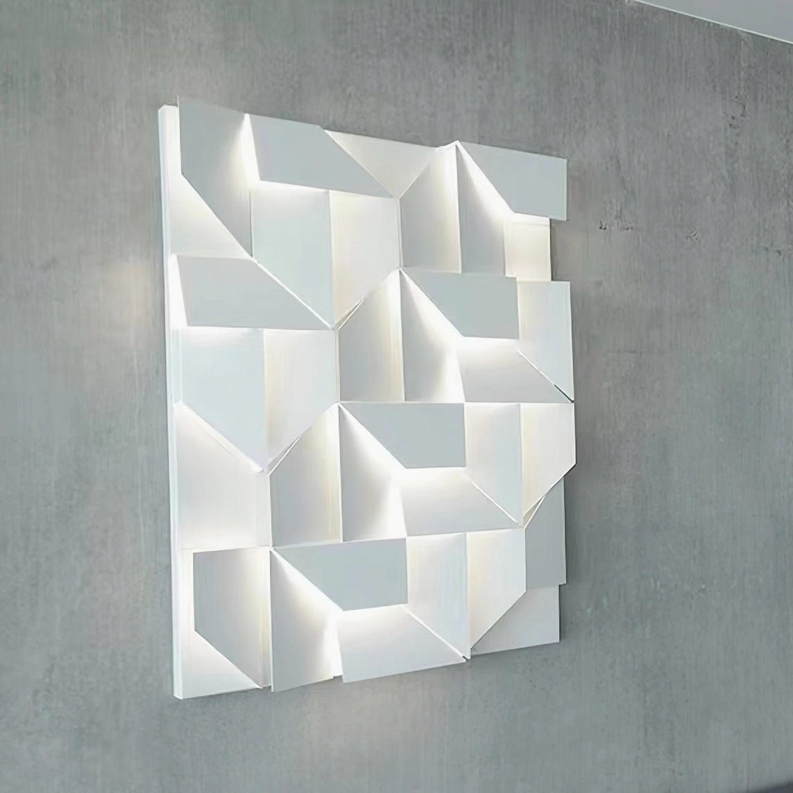 3D laser-cut geometric wall lamp mounted on concrete textured wall with warm LED backlighting