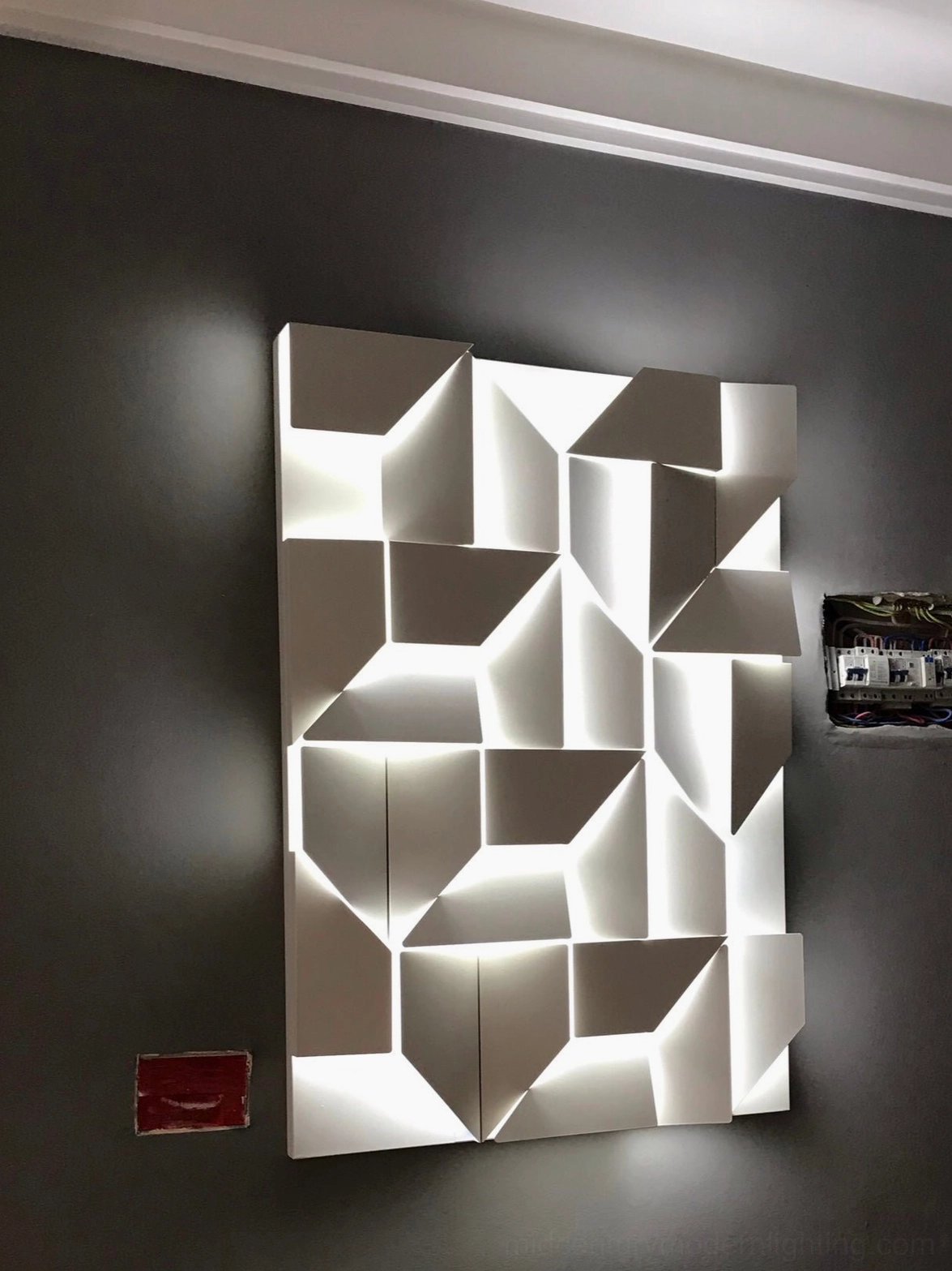Contemporary wall sconce with geometric cutout pattern, integrated warm LED light