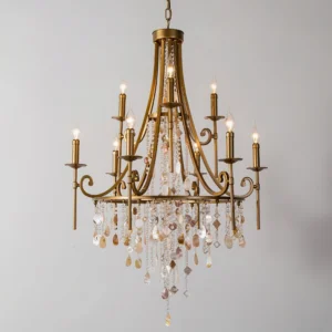 Luxury brass chandelier close-up detail of curved candle arms with dangling crystal beads and natural shell accents