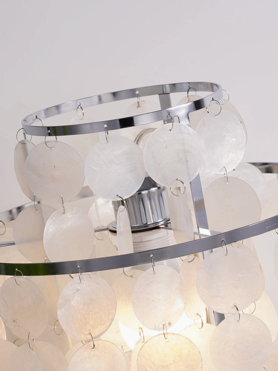 Modern mother-of-pearl shell table lamp with chrome finish in contemporary setting