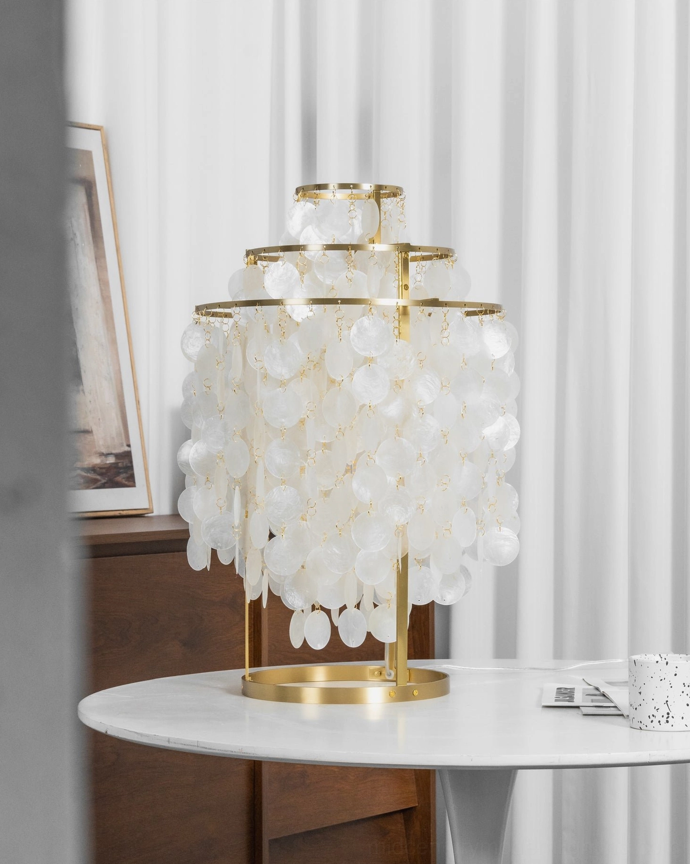 Contemporary mother-of-pearl shell lamp with brass gold metal frame and warm soft illumination
