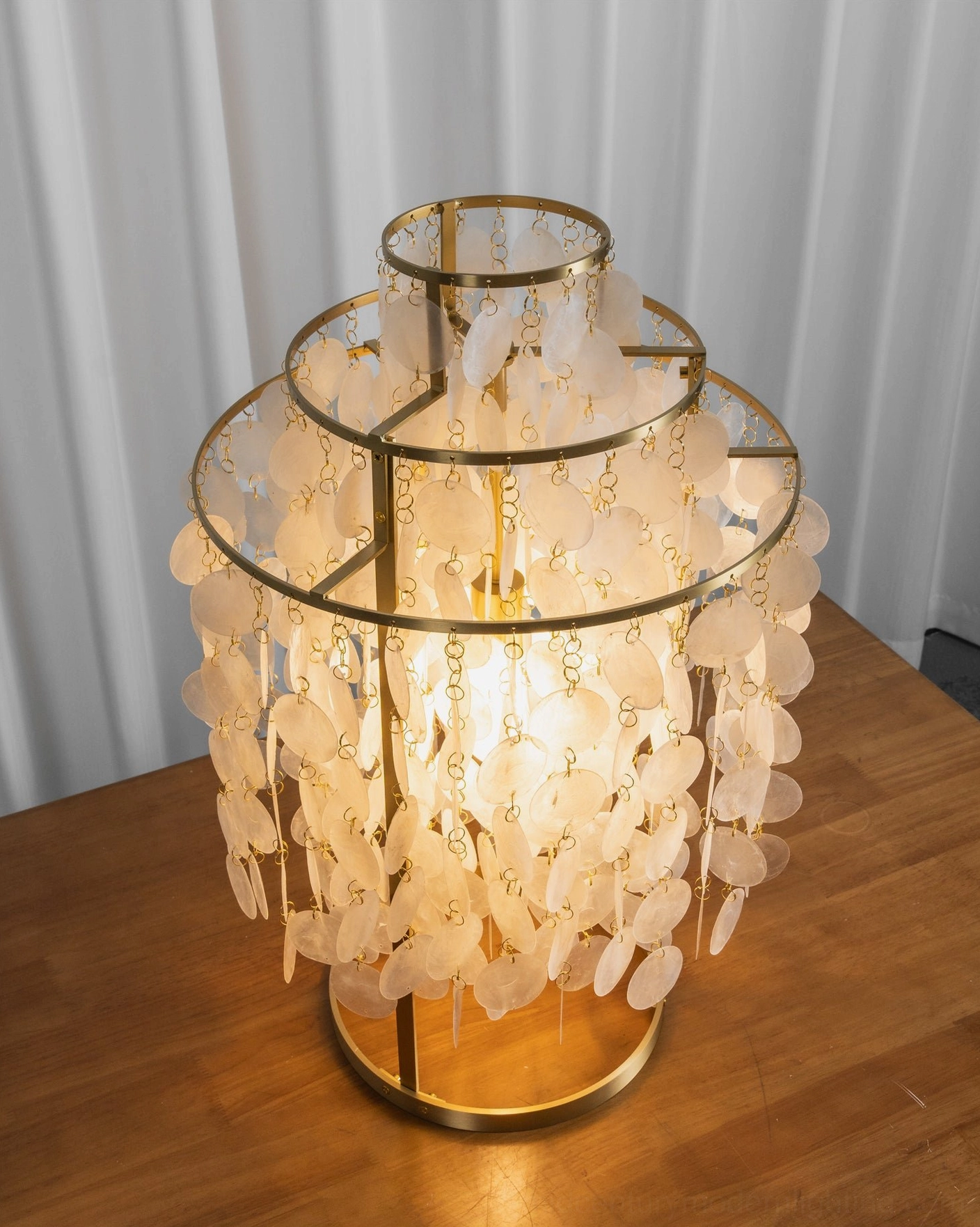 Capiz shell table lamp overhead view on wooden dining table with soft warm glow