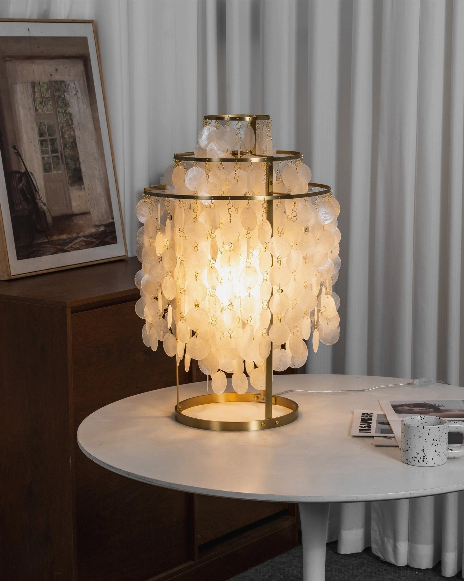 Vintage-inspired mother-of-pearl shell table lamp with warm gold finish and brass frame on side table with framed art