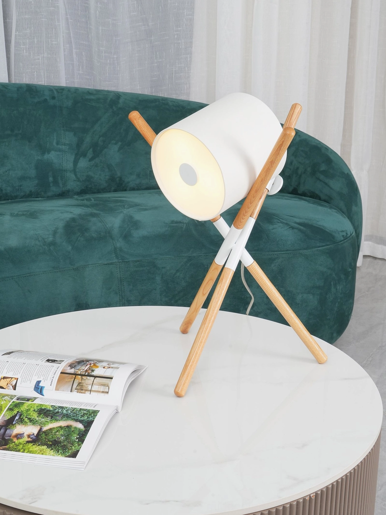 Modern tripod table lamp with white shade and natural wood legs in contemporary interior setting