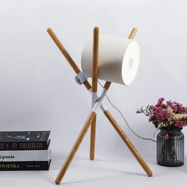 Side view of mid-century modern wood tripod table lamp with white cylindrical shade and visible power cord