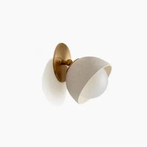 Shoal travertine wall sconce with brass hardware mounted on white background - front side view showing spherical stone diffuser and metal backplate
