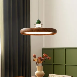 Mid-century modern pendant light with walnut finish and green spherical finial in retro dining room