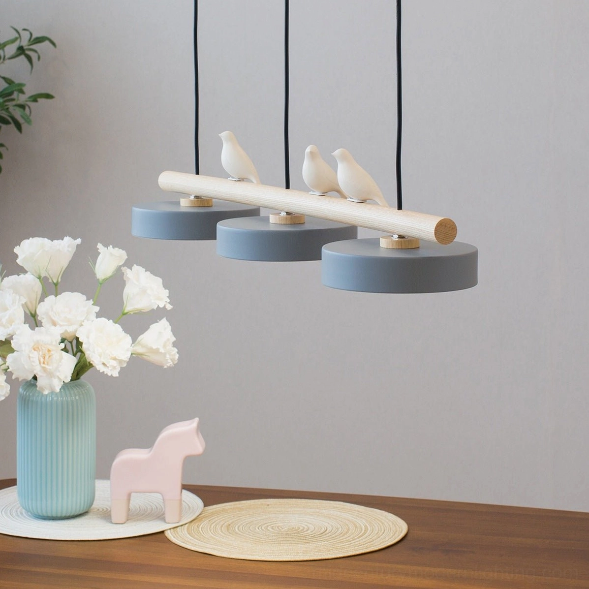 Sienna bird pendant fixture hanging above dining table with warm Nordic home decor styling