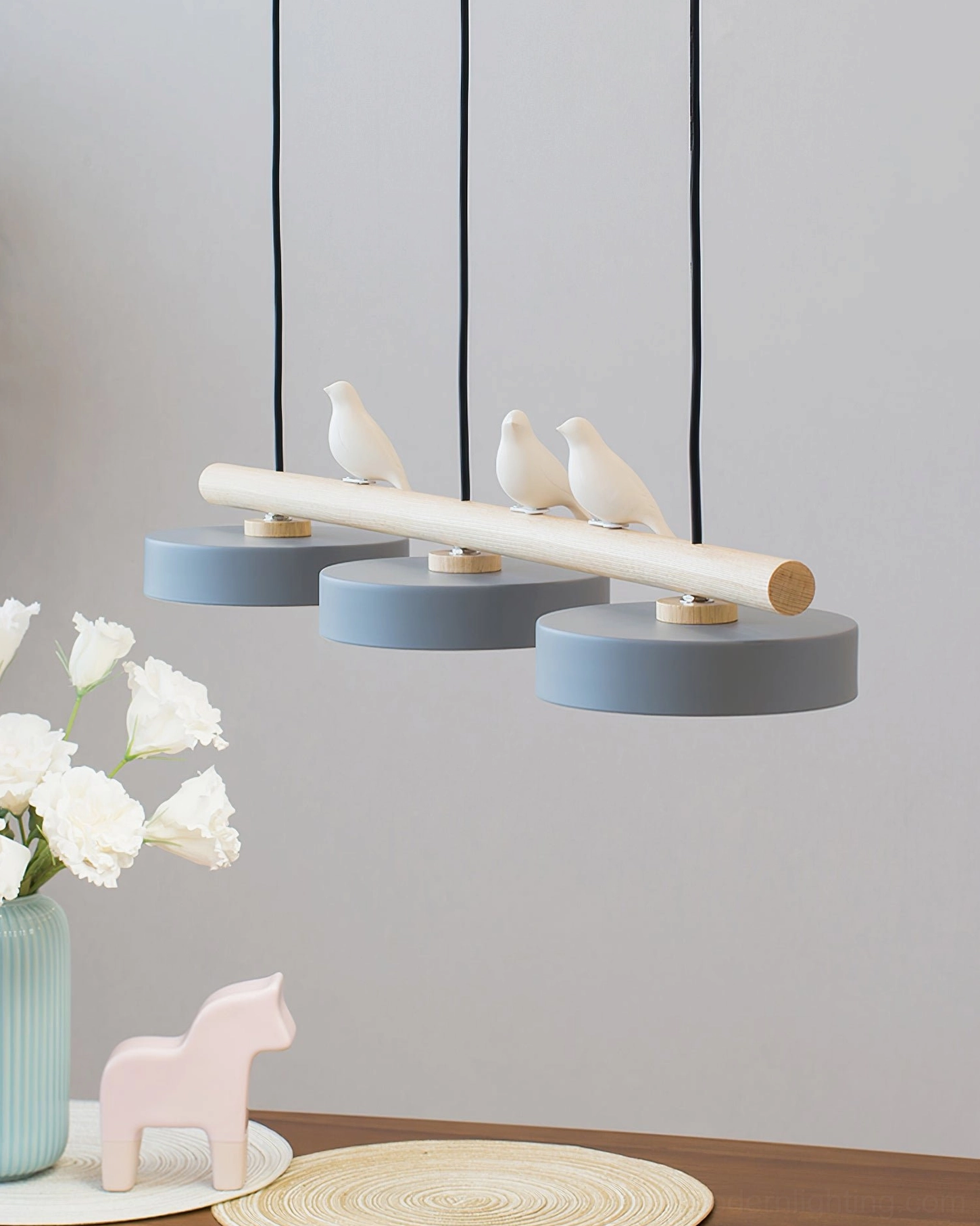 Contemporary linear pendant lamp with bird motifs showing warm lighting effect in room