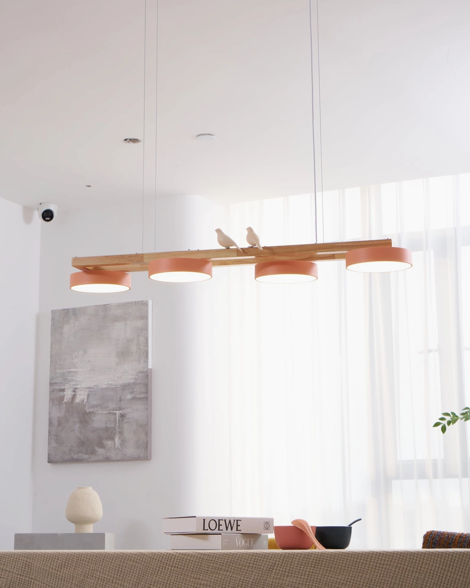 Four-head pink Sienna Bird Linear Chandelier in Scandinavian interior with wooden furnishings
