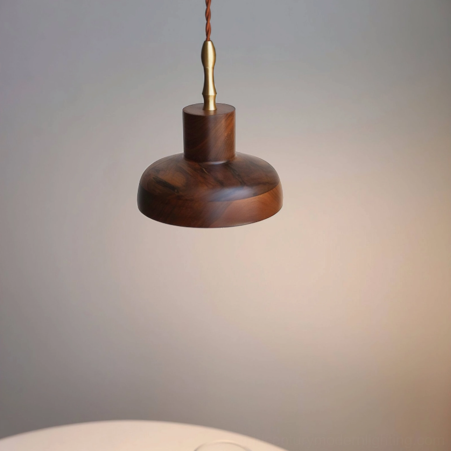 Overhead front view of silas walnut pendant dome showing continuous wood grain structure, brass hardware joint, partial table edge
