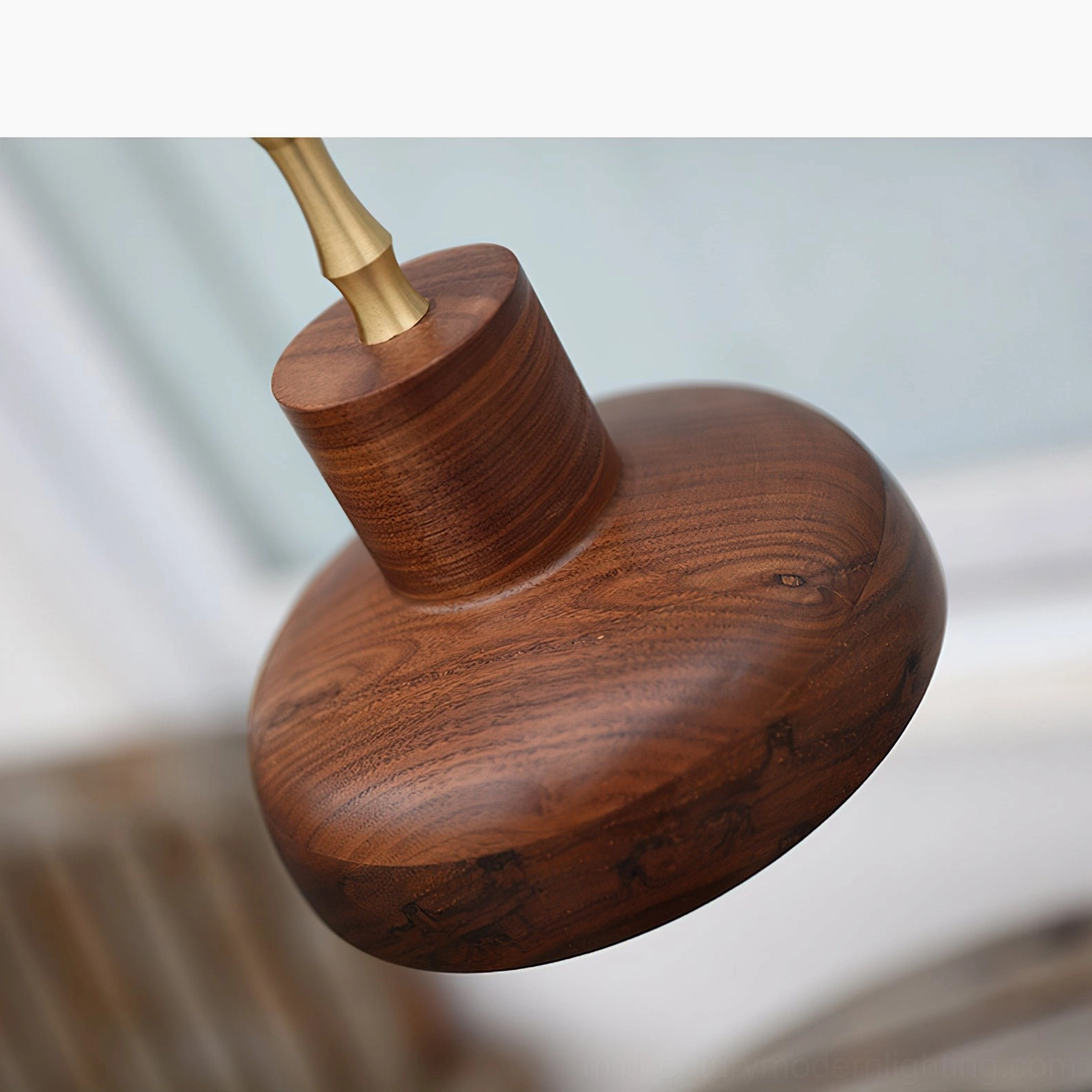 Walnut dome shade with visible natural wood grain texture and brass connector detail photographed at oblique angle with interior blur
