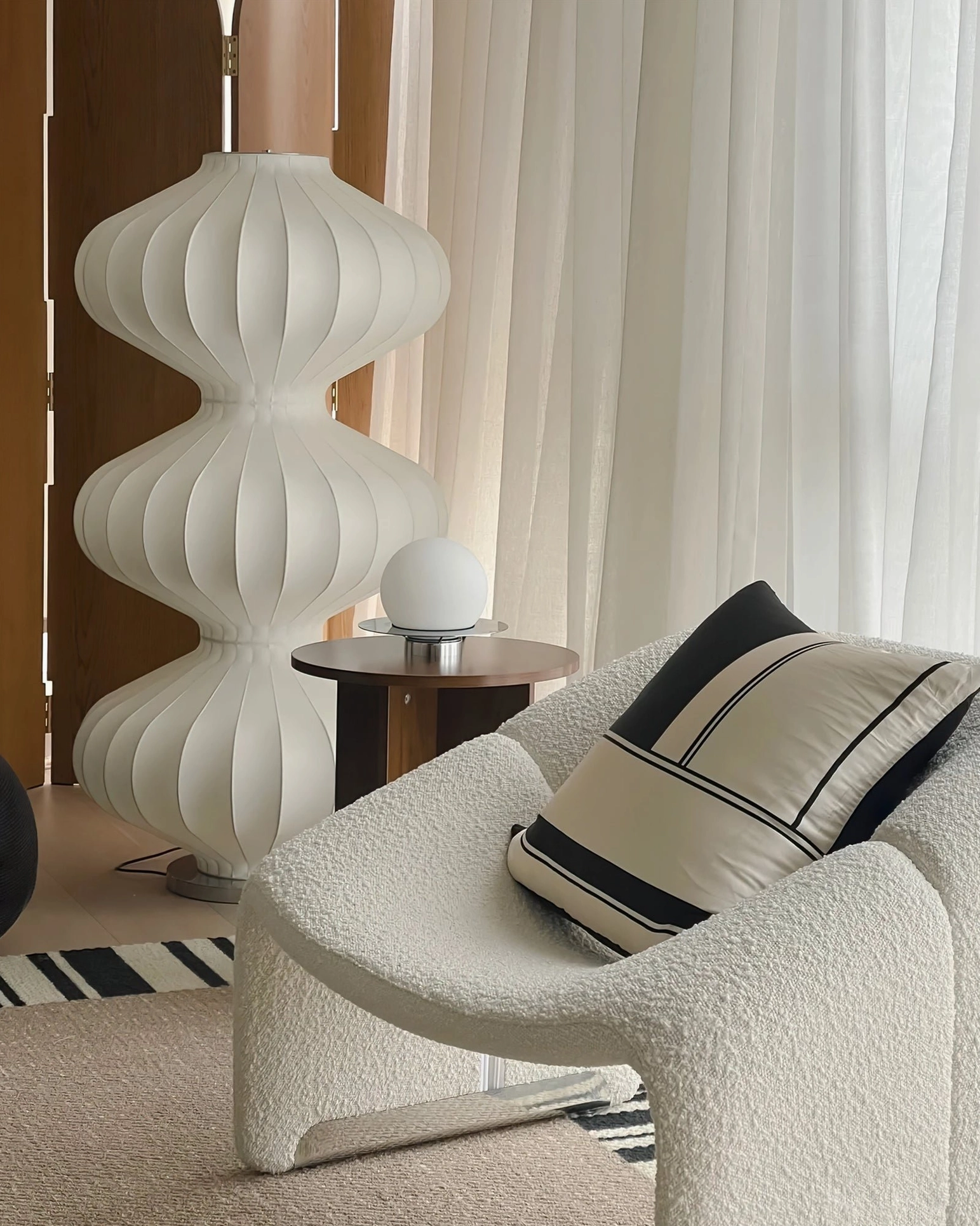 White ribbed silk gourd floor lamp three-quarter view paired with boucle chair in cozy modern living room