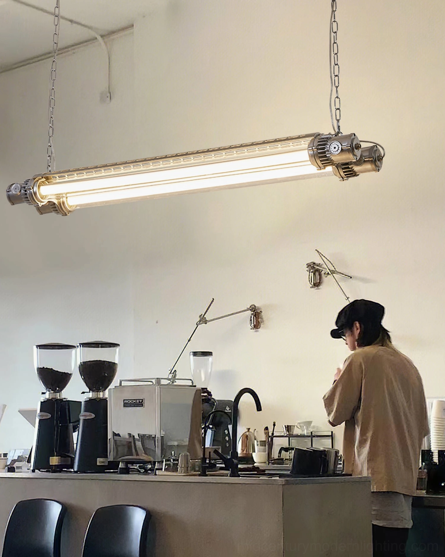 Double tube silver LED chandelier installed in contemporary cafe counter space with barista, industrial ambiance
