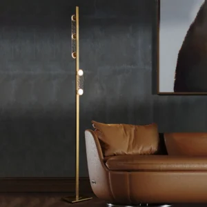 Sinclair gold floor lamp casting warm ambient light in modern dark luxury living room with leather sofa